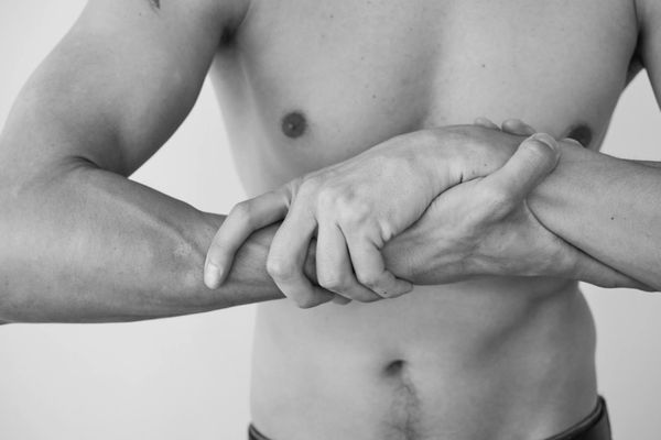 Man holding a difficult balance pose with concentration.